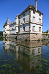 Building by lake against sky