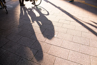 High angle view of people shadow on sidewalk