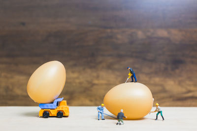 Optical illusion of figurines working on eggs