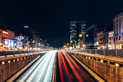 Light trails on road along buildings at night