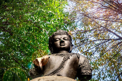 Low angle view of statue against trees