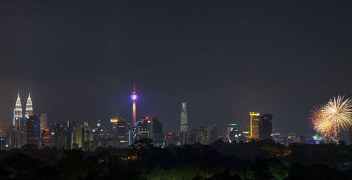 Illuminated buildings against sky at night