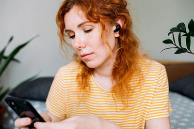 Portrait of young woman using mobile phone at home