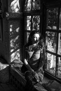 Portrait of woman looking through window