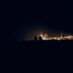 Silhouette people in water at night