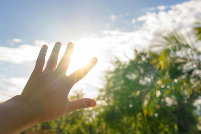 Close-up of hand against sky