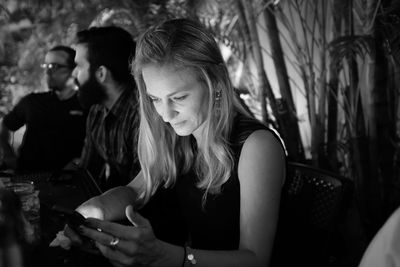 Woman using smart phone while sitting at party