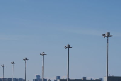 Low angle view of street lights against clear blue sky