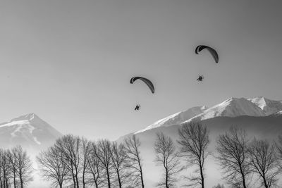 Low angle view of people flying against sky