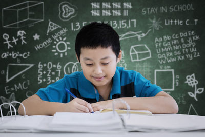 Worried boy studying at table