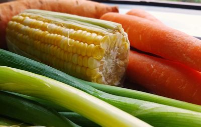 Close-up of carrots, corn, spring onions 