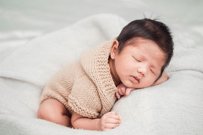 High angle view of baby sleeping on bed