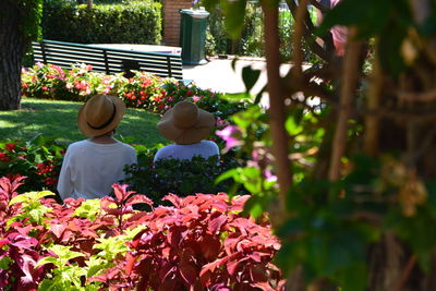 Rear view of people on flowering plants