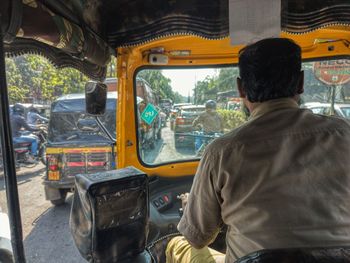 Rear view of man riding an auto rickshaw