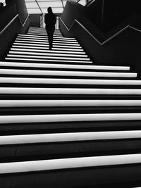 Rear view of woman walking on illuminated steps