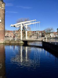 Reflection of built structure in water against blue sky