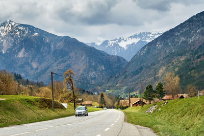 Road by mountains against sky