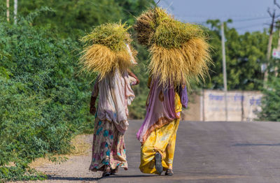 Rear view of women walking on road
