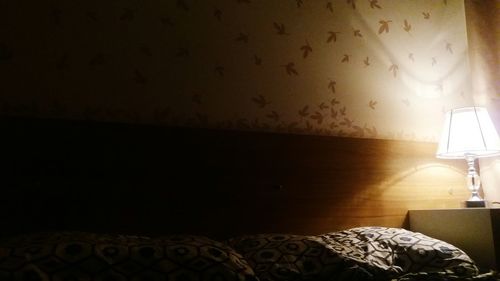 Illuminated lamp on side table at bedroom