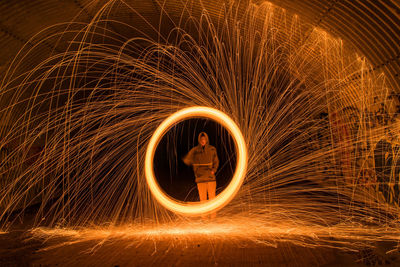 Blurred motion of man standing in illuminated tunnel