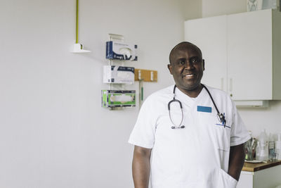 Portrait of smiling male doctor with hand in pocket at hospital