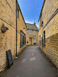 Footpath amidst buildings against sky