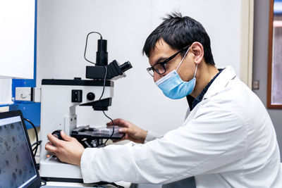 Male scientist using microscopy in laboratory