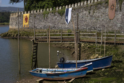 Boats moored on river by trees