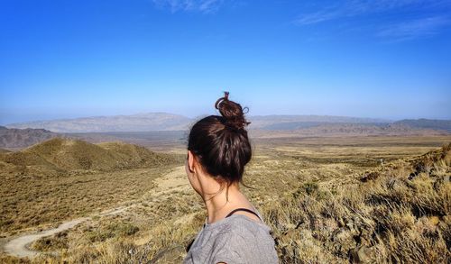 Rear view of woman on landscape against sky