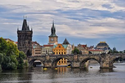 Arch bridge over river against buildings