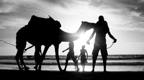 Silhouette people standing against sky