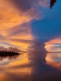 Scenic view of sea against dramatic sky during sunset