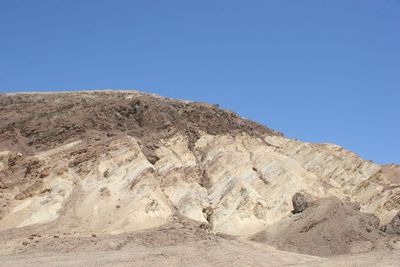 Scenic view of arid landscape against clear blue sky