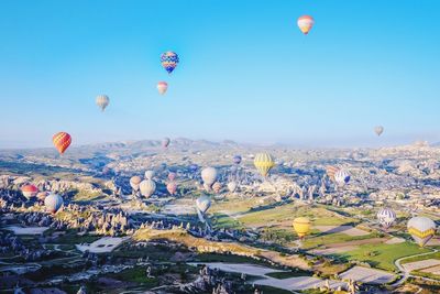 View of hot air balloon over mountains against sky during winter