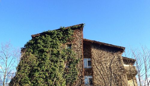 Low angle view of old building against clear blue sky