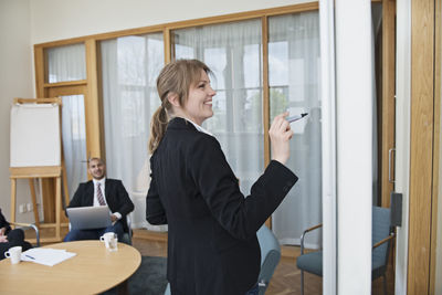 Woman writing on board in conference room, stockholm, sweden