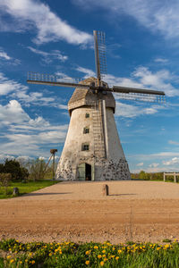 Traditional windmill on field against sky