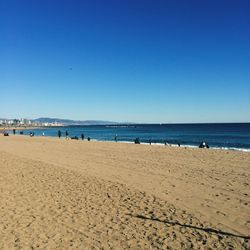 Scenic view of beach against clear blue sky