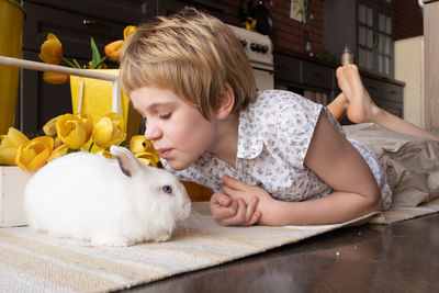 Girl kissing rabbit at home