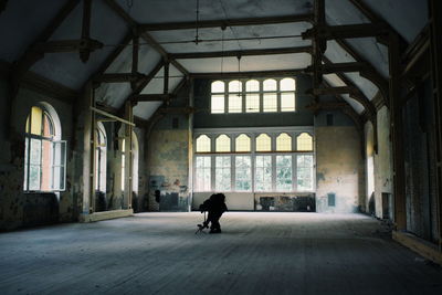 Rear view of woman walking in abandoned building