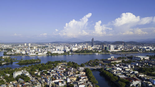 Aerial view of city by sea against sky