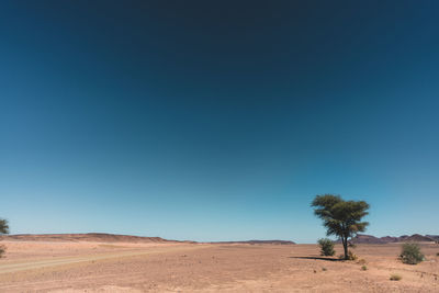 Scenic view of desert against clear blue sky