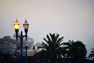 Low angle view of illuminated street light against sky