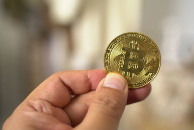 Close-up of hand holding coins