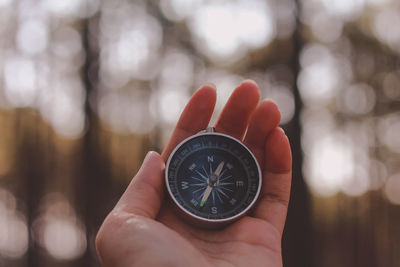 Close-up of hand holding navigational compass