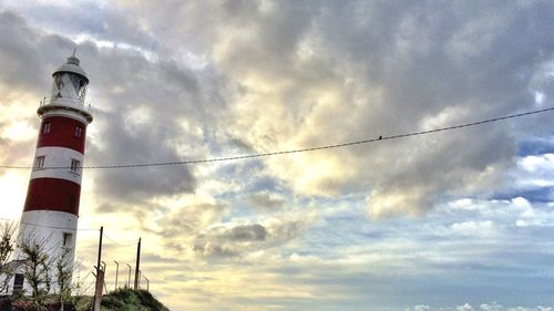 Low angle view of lighthouse against cloudy sky