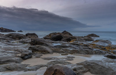 Rocks on beach against sky