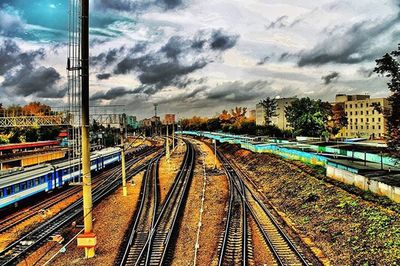 Railroad tracks against cloudy sky