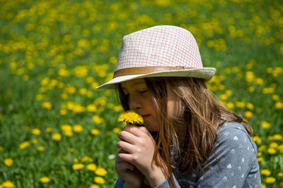 Portrait of woman with yellow flower in park