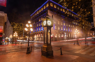 Illuminated buildings in city at night gastown steam clock